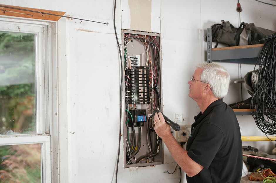Électricien inspectant un tableau électrique avant le raccordement d'une motorisation