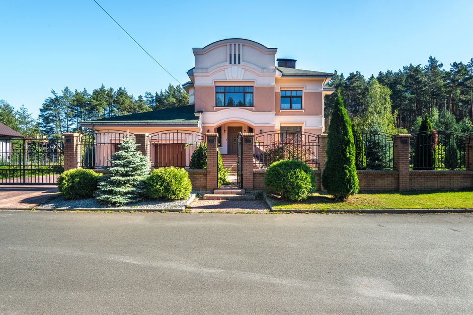 Maison avec portail et clôture d'entrée dans un jardin paysager