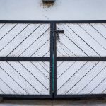 Portail à deux vantaux battants en bois et métal, fermé sur un pilier