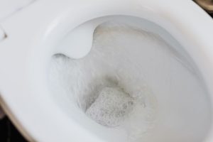 Eau de chasse tourbillonnant dans une cuvette de WC blanche