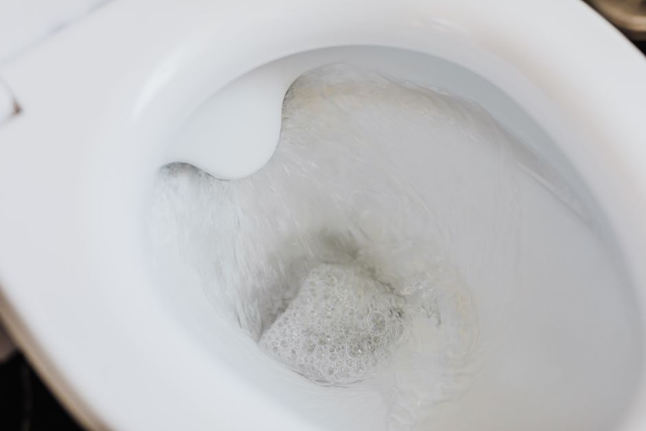 Vue du dessus d'une cuvette de WC blanche avec de l'eau mousseuse